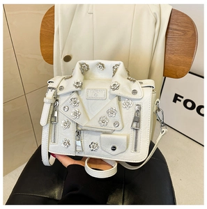 Detailed view of white motorcycle jacket shape bag with silver floral studs and rhinestones