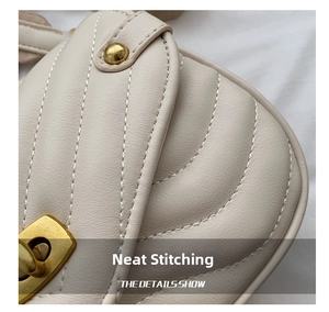 Detailed macro view of beige quilted leather stitching and vintage gold clasp hardware