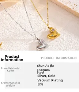 Detail of gold and silver heart pendants with inlaid zircon on titanium steel necklaces
