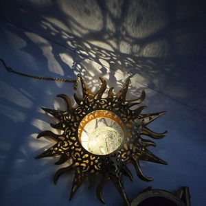 Detail of warm glow through cracked glass ball and hollow metal sun lantern