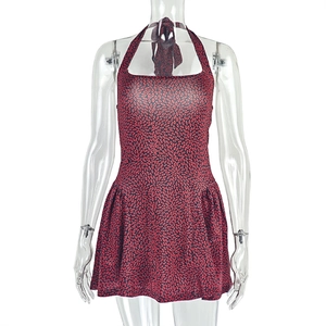 Detail of red and black floral print on a halter backless mini dress with tie neck