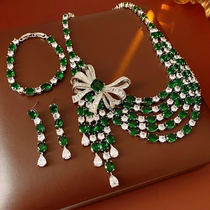 Vue détaillée d'une parure de bijoux nœud en argent avec zircons verts et brillants