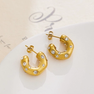Detailed close-up of 18k gold plated C-shaped earrings with sparkling cubic zirconia