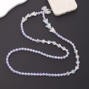 Iridescent pearl bead phone charm with butterfly and heart charms on black background