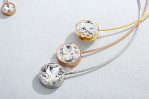 Macro shot of large zircon pendants in gold, rose gold, and silver stainless steel finishes