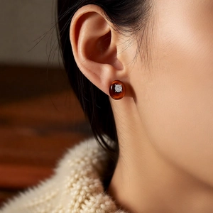 Detailed close-up of oval brown tiger eye stud earrings with a central cubic zirconia