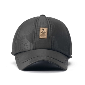Detail of winter baseball cap with dark grey textured fabric and brown leather patch