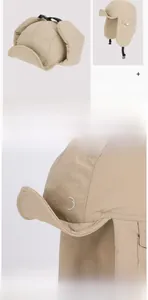 Detail of khaki earflap hat showing water-resistant fabric and side pocket buckle