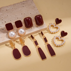 Vue détaillée de cinq paires de boucles d'oreilles vintage en résine rouge et perles dorées