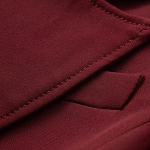 Detailed close-up of dark red fabric texture and precise stitching on the slim-fit coat