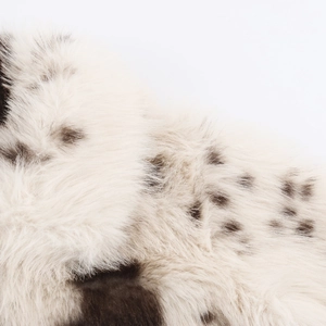 Macro detail of soft faux fur fabric with leopard animal print pattern in cream and brown