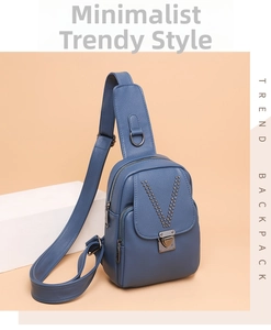 Détail du sac de poitrine en cuir bleu foncé avec motif en V riveté et boucle métallique
