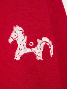 Dettaglio macro del maglione rosso lavorato a maglia con motivo jacquard a cavallo bianco