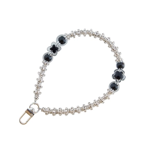Short silver metal chain phone strap with black floral beads and spherical pearls on white background