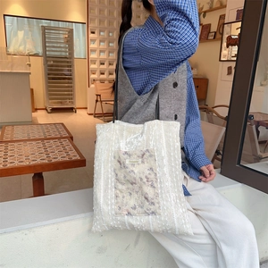 Detail of floral patch pocket and lace texture on vintage canvas tote bag
