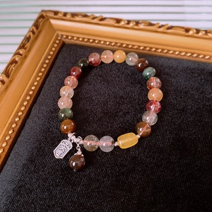 Macro shot of multi-color crystal beads with vintage silver tag on black velvet