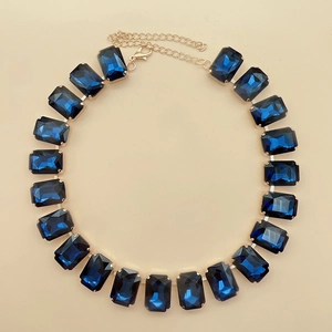 Detail view of rectangular blue crystal necklace with gold-plated link chain