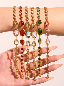 Detailed shot of layered golden anklets with colorful Czech glass gems on a model