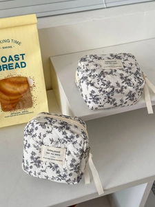 Detail of quilted floral storage bags with zip closure and cotton ribbon pullers