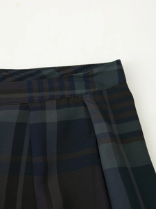 Détail du pantalon à carreaux taille haute avec motifs bleu marine et vert forêt foncés