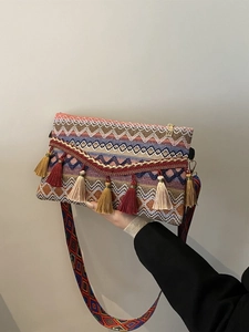 Close-up of colorful ethnic woven crossbody bag with vibrant tassels and wide strap