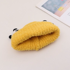 Dettaglio della fascia panda in peluche giallo con morbida texture in pile corallo
