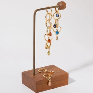 Colorful teardrop gemstone earrings with gold plated hoops on a walnut wooden display