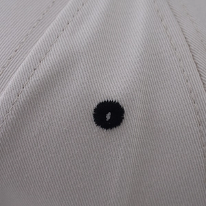 Détail macro de l'œillet brodé de haute qualité sur le tissu en sergé de coton du bonnet