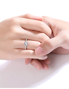Close-up of 1 carat Moissanite ring in silver setting worn on hands for a warm feeling