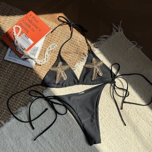 Detailed view of handcrafted gold and silver starfish beads on black bikini top