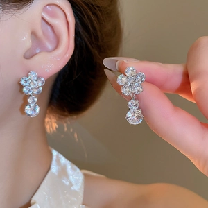 Macro detail of zircon flower earrings in silver finish with sparkling round crystals