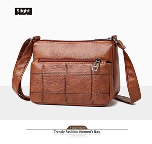 Three-layer zipper compartments and quilted leather detail on brown crossbody bag
