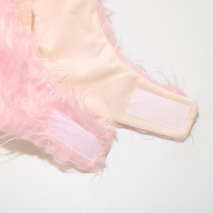 Détail du bonnet d'hiver en peluche rose avec sangle réglable à bande auto-agrippante