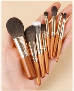 Detailed close-up of 7 mini makeup brushes with natural wood handles and gold ferrules