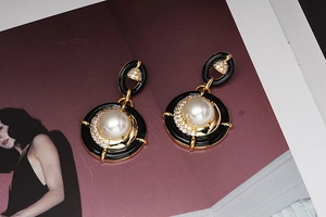 Détail de boucles d'oreilles vintage en émail avec perles et zircons sur base dorée