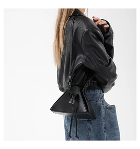 Detail of black punk triangle crossbody bag with skull charm and drawstring closure