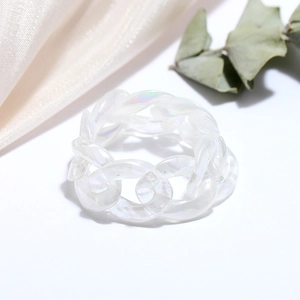 Macro shot of translucent iridescent resin chain ring with pearlescent finish details