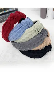 Detail of six wide knotted headbands featuring textured fabric in multiple colors
