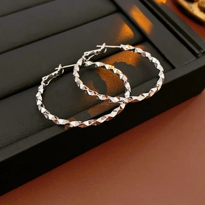 Dettaglio di orecchini a cerchio argento con texture scintillante taglio diamante