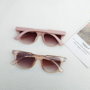 Detail view of retro square oversized sunglasses in matte pink and champagne frames