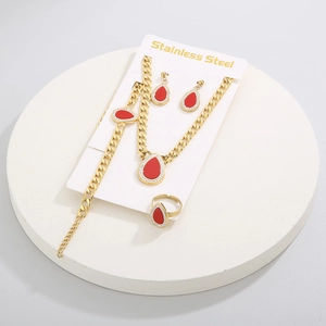 Detail view of 4-piece gold stainless steel jewelry set with red teardrop pendants