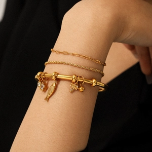 Ensemble de trois bracelets en acier inoxydable plaqué or 18k avec breloques sur mannequin