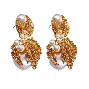 Detailed close-up of vintage gold leaf earrings with white pearls and sparkling rhinestones