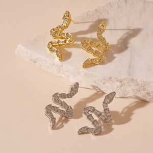 Elegant gold and silver snake-shaped earrings with zircon accents on natural stone