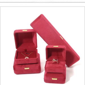 Macro detail of burgundy velvet jewelry boxes with gold clasps for rings and necklaces