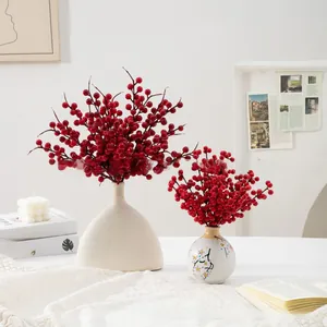 Close-up of vibrant artificial red berries in stylish ceramic vases on a lace tablecloth