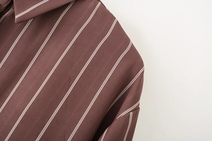 Detailed close-up of dark brown vertical striped shirt collar and woven fabric texture