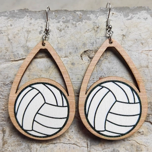 Primo piano di orecchini pendenti in legno a goccia con motivo a palla da pallavolo