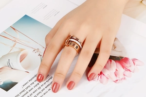 Close-up of rose gold Roman numeral ring and pavé eternity band on a woman's hand
