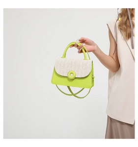 Close-up of stylish neon green and beige woven handbag with a circular buckle detail